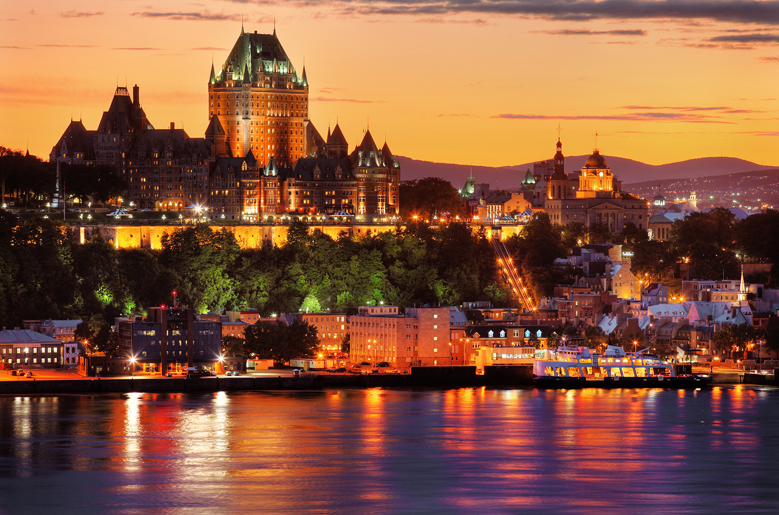 Wide shot of the Fairmont Le Ch&acirc;teau during sunset, river in foreground.
