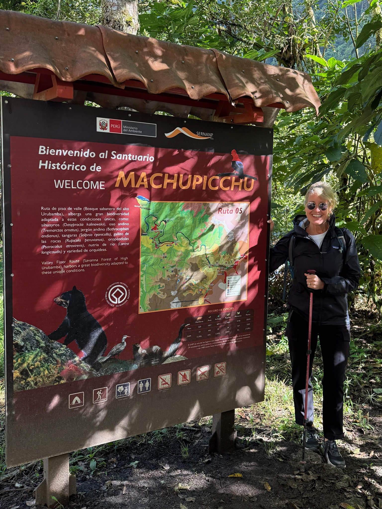 Woman standing next to a trail map