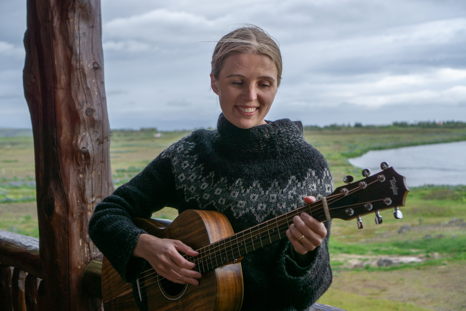 Woman smiling while playing the guitar