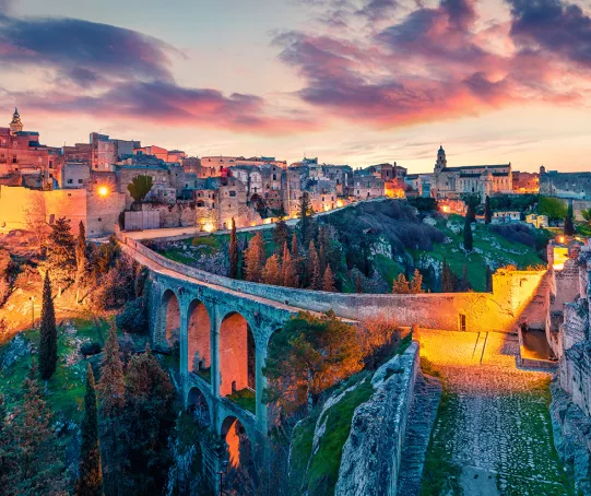 Illuminated town buildings with a bridge connecting two portions of buildings together