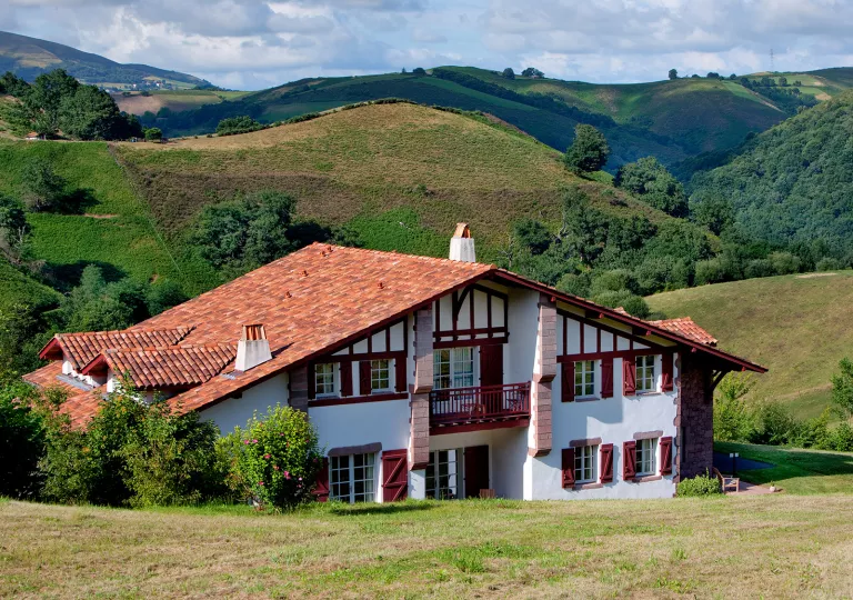 Exterior of white building with red accents and a red roof