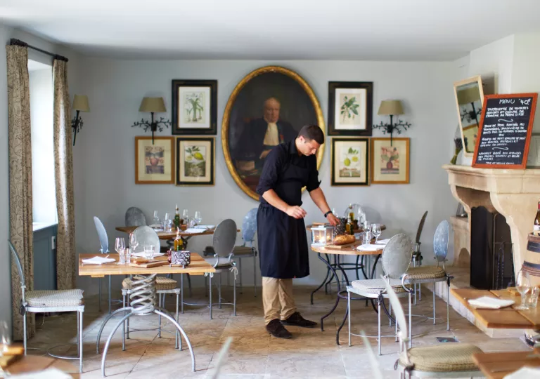 waiter setting table in dining room
