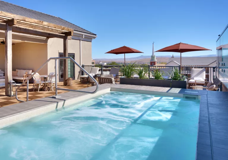 Outdoor pool on a roof, looking out to a small town in the distance