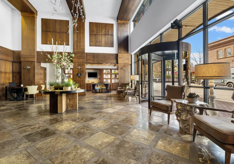 Indoor lobby view with a glass wall and rotating door leading to the outdoors