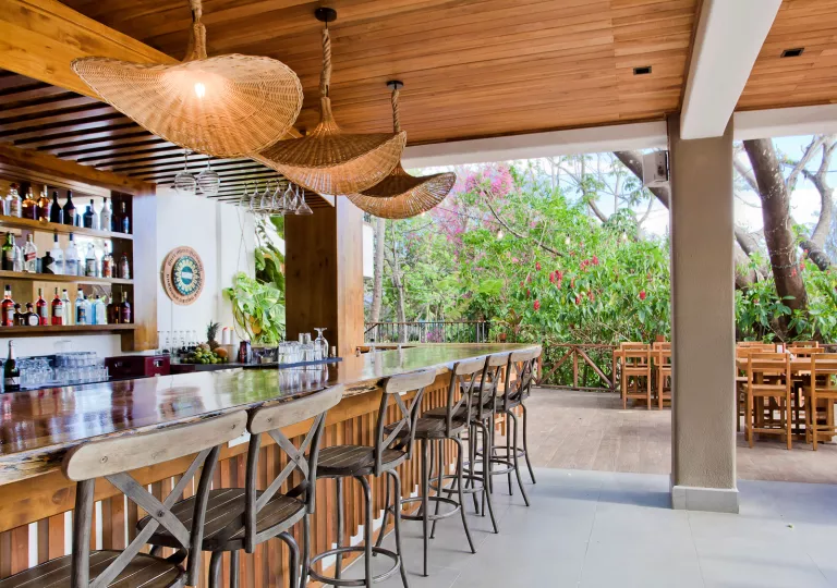 Outdoor patio and bar with wooden bar counters and stone pillars