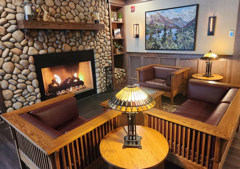Cushioned sofas surrounded a lit, stone fireplace