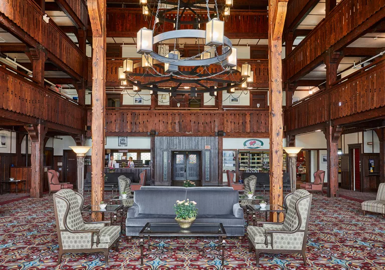 Indoor hotel lobby with cushioned seats and two concierges