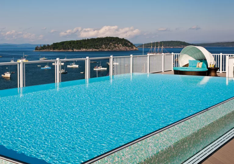 Outdoor pool overlooking the ocean, filled with boats