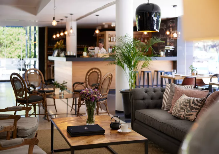 Bar with chairs and couches and a bartender in the background