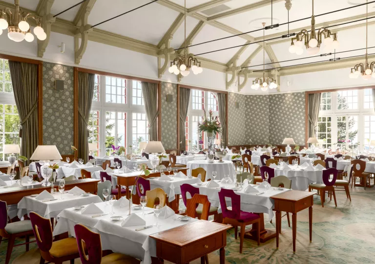hotel restaurant with green curtains and chandeliers