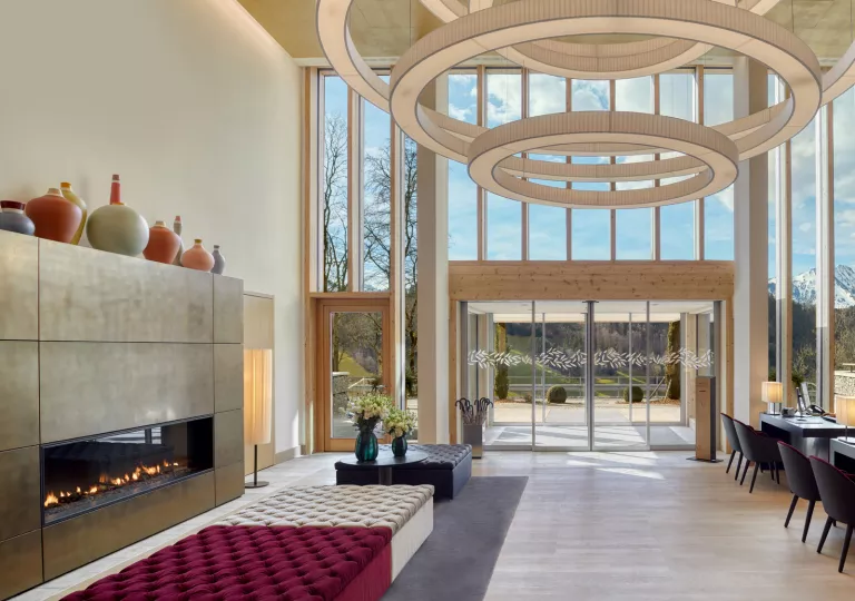 Indoor lobby with a stone fireplace and cushioned sofas in the center