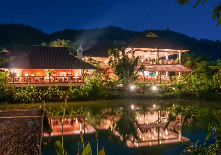 Outdoor bungalows illuminated by lights in the evening