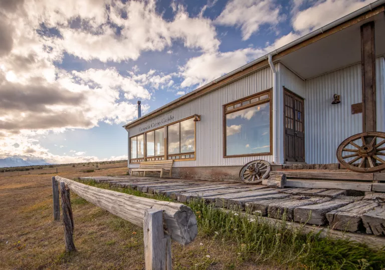 Metal building with a wooden porch and wooden wheels in front