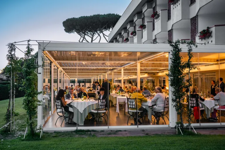 Dining hall with large, glass walls and people inside eating
