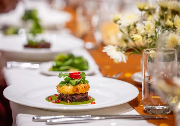 Plate full of fancy food on a dining table