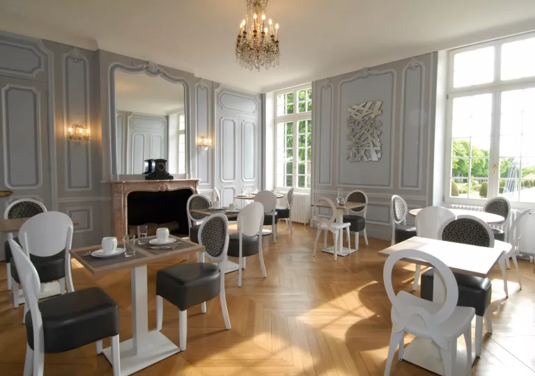Room with wooden flooring and black and white chairs, with a small chandelier from the ceiling