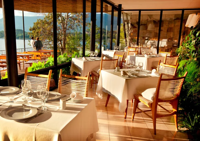 Dining area with large windows and the sunshine hitting each dining table