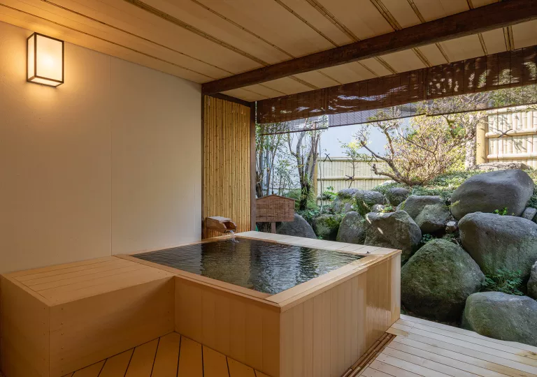 Outdoor hot tub with large boulders in front