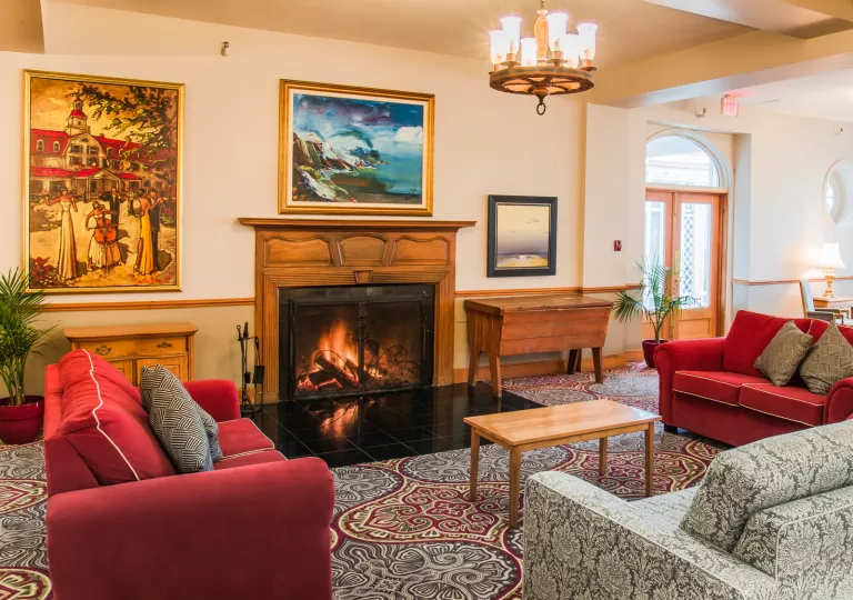 Lounge and seating area in front of a fireplace, with painting hanging on the wall