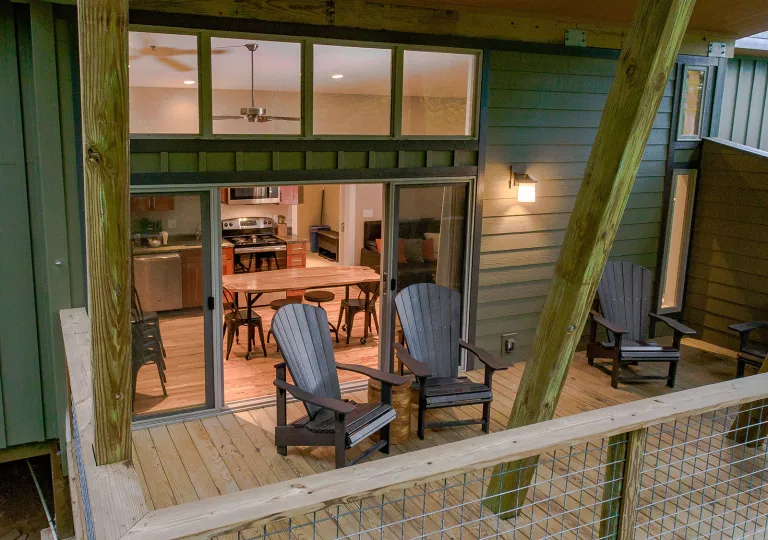 Outdoor patio with two chairs and a kitchen in the background