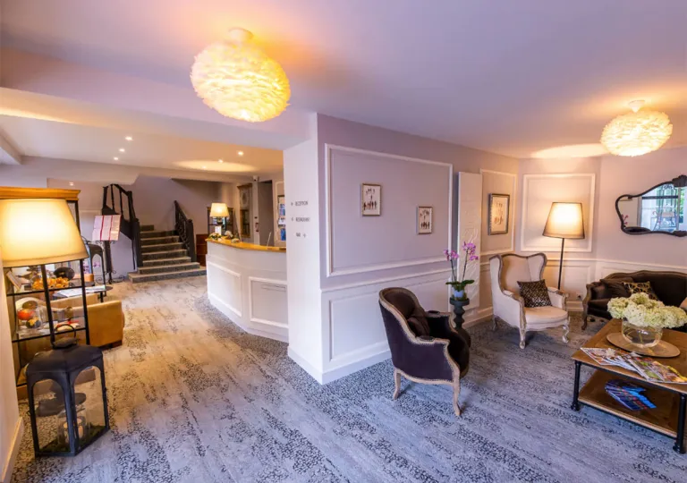 Hotel lobby area with cushioned sofas and couches, and round light fixtures