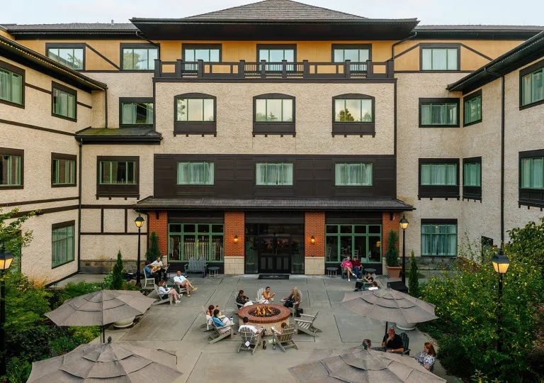 Exterior view of large hotel complex building, with large windows and an outdoor courtyard