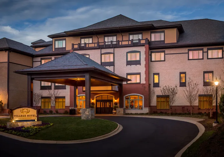 Evening, exterior view of a large hotel building with a front patio