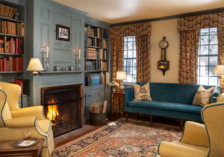 Living room area with blue and beige couches in front of a fireplace
