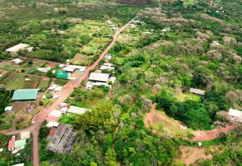 Sky view of a small village in the middle of a large field with dirt trails