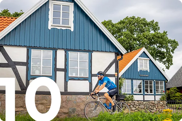 text:1-; image: Biker cycling by a blue house
