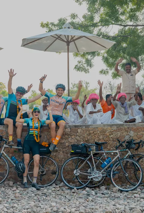 Backroads employees and posing on a wall with a community on India Staff Ride
