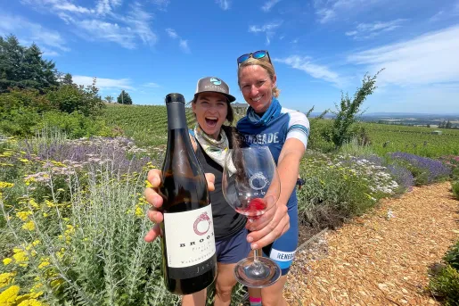Two guests/leaders showing a wine bottle and glass to the camera.