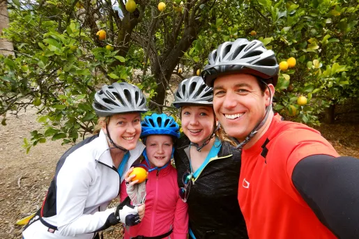 Four guests taking a selfie, orange tree behind them.