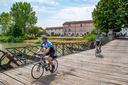 Cyclists crossing a wooden bridge in Veneto