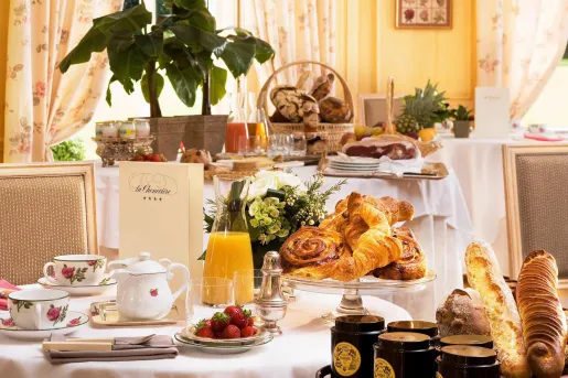 Dining tables with plates of pastries, fruit and glasses