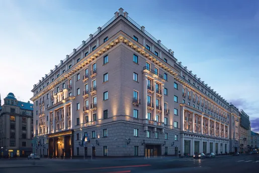 Outdoor view of hotel building with lots of windows, illuminated by orange lights along the walls