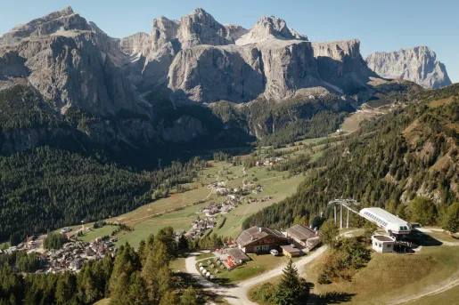 Large mountains in the background with small buildings on ground level