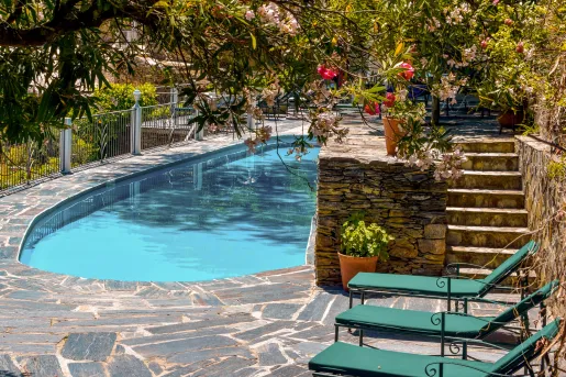 Outdoor pool area with stone walkways and green pool chairs