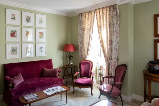 living room with red velvet furniture and framed picture frames