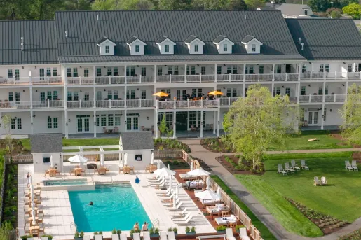 Large, white building with outdoor balconies looking out to an outdoor pool