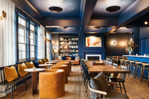 Indoor lounge with blue walls and brown, cushioned chairs