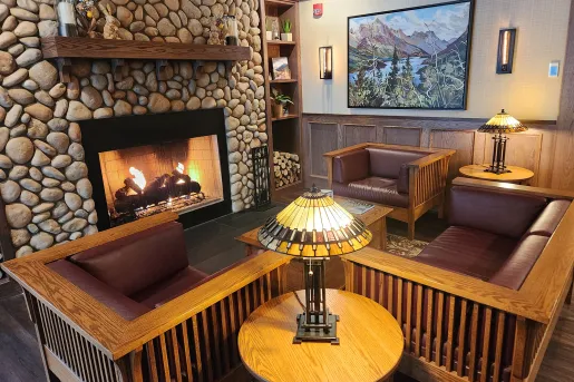 Cushioned sofas surrounded a lit, stone fireplace