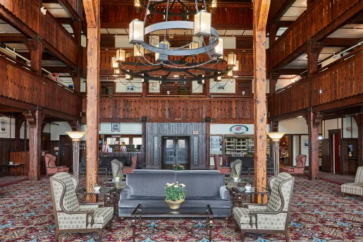 Indoor hotel lobby with cushioned seats and two concierges 