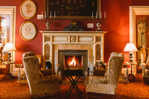 Two cushioned seats in front of a fireplace