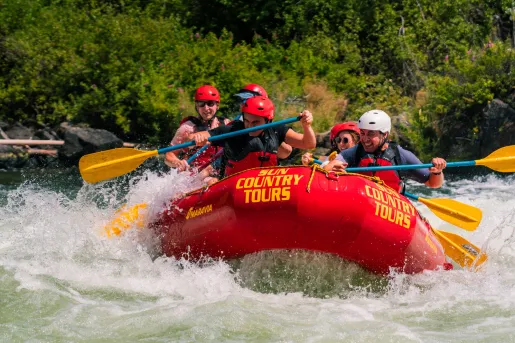 Group of people on a red rafting, paddling through a river