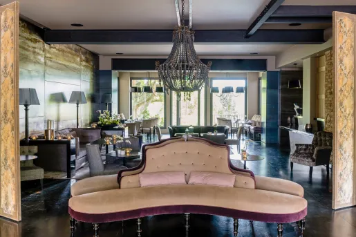 Indoor lounge with a large chandelier and cushioned sofas 