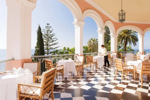 Outdoor patio with dining tables and a waitress prepping the tables