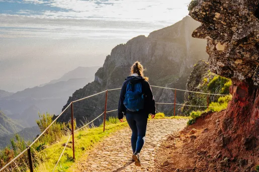Woman walking on a stone path descending on a mountain
