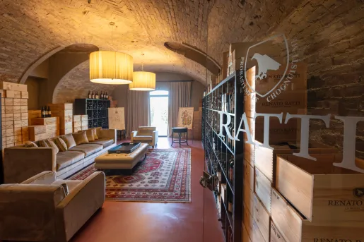 Stone cellar with cushioned seats and shelves full of wine