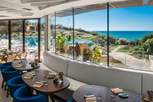 Indoor dining common area with large windows looking out to the ocean